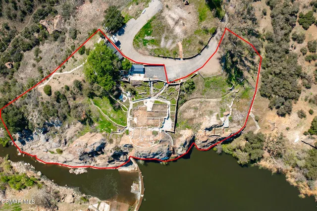 an aerial view of a house with a yard and large trees