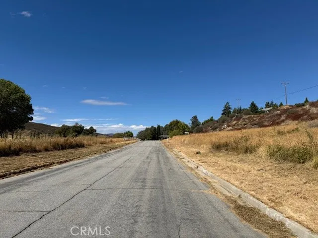 a view of a dry yard with wooden fence