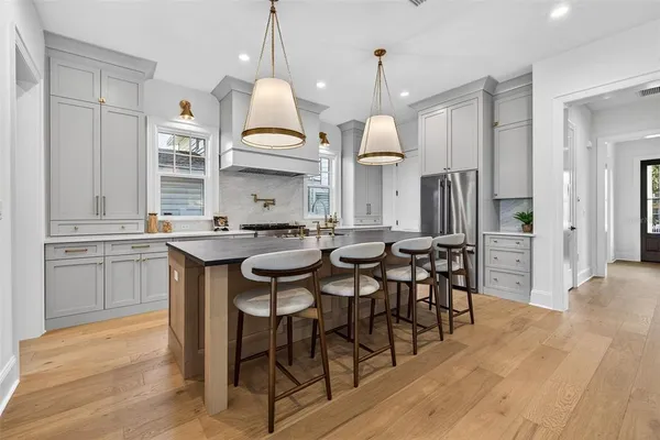 a kitchen with cabinets a sink dining table and chairs