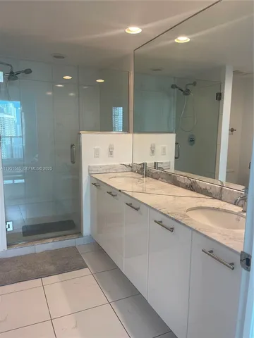 a bathroom with a granite countertop sink a toilet a mirror and shower