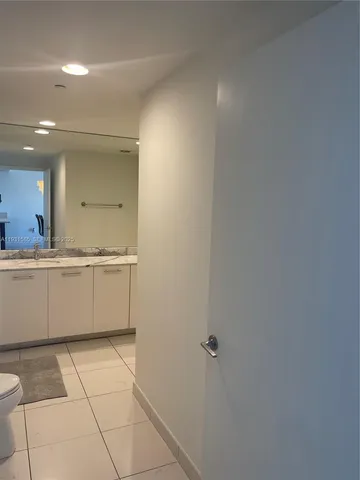 a large white bathroom with a sink a vanity and a mirror