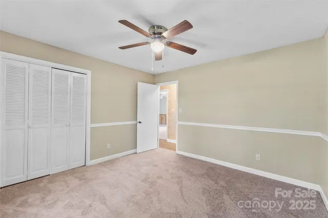 an empty room with closet and ceiling fan