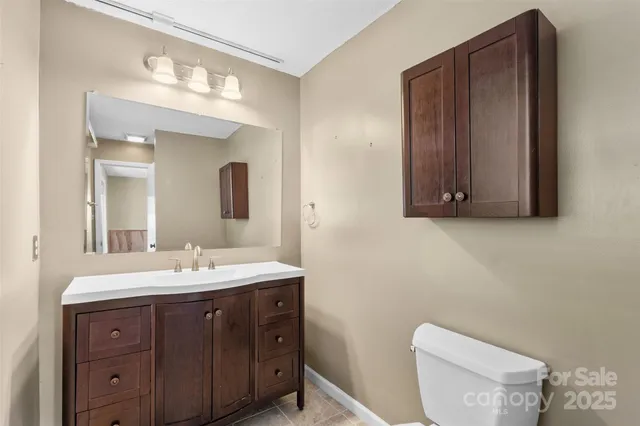 a bathroom with a toilet a sink and mirror