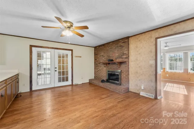 wooden floor fireplace and windows in an empty room