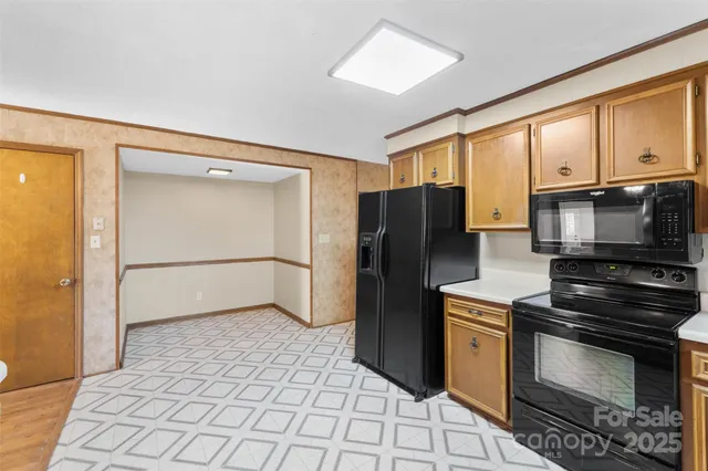 a kitchen with granite countertop a refrigerator and a stove top oven