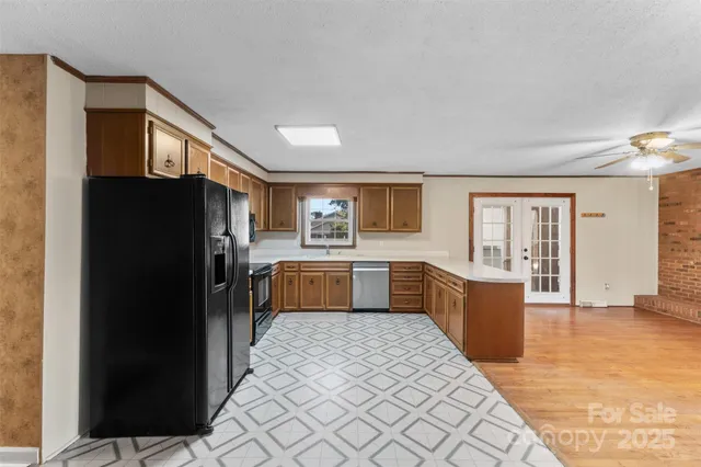 a large kitchen with a refrigerator and wooden cabinets