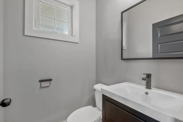 a bathroom with a sink a toilet and mirror