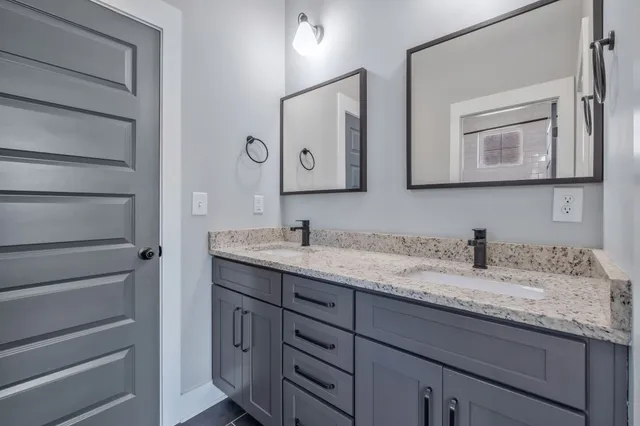 a bathroom with a granite countertop sink vanity and mirror