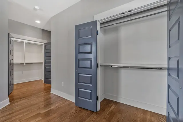 a view of walk in closet with wooden floor
