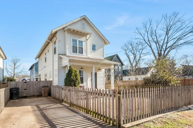 a view of a house with a small yard and wooden fence