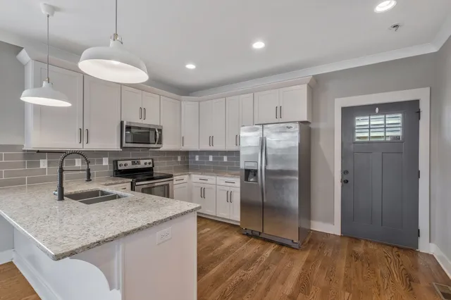 a kitchen with kitchen island a counter top space stainless steel appliances and cabinets