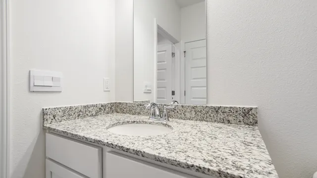 a bathroom with a granite countertop sink and a mirror