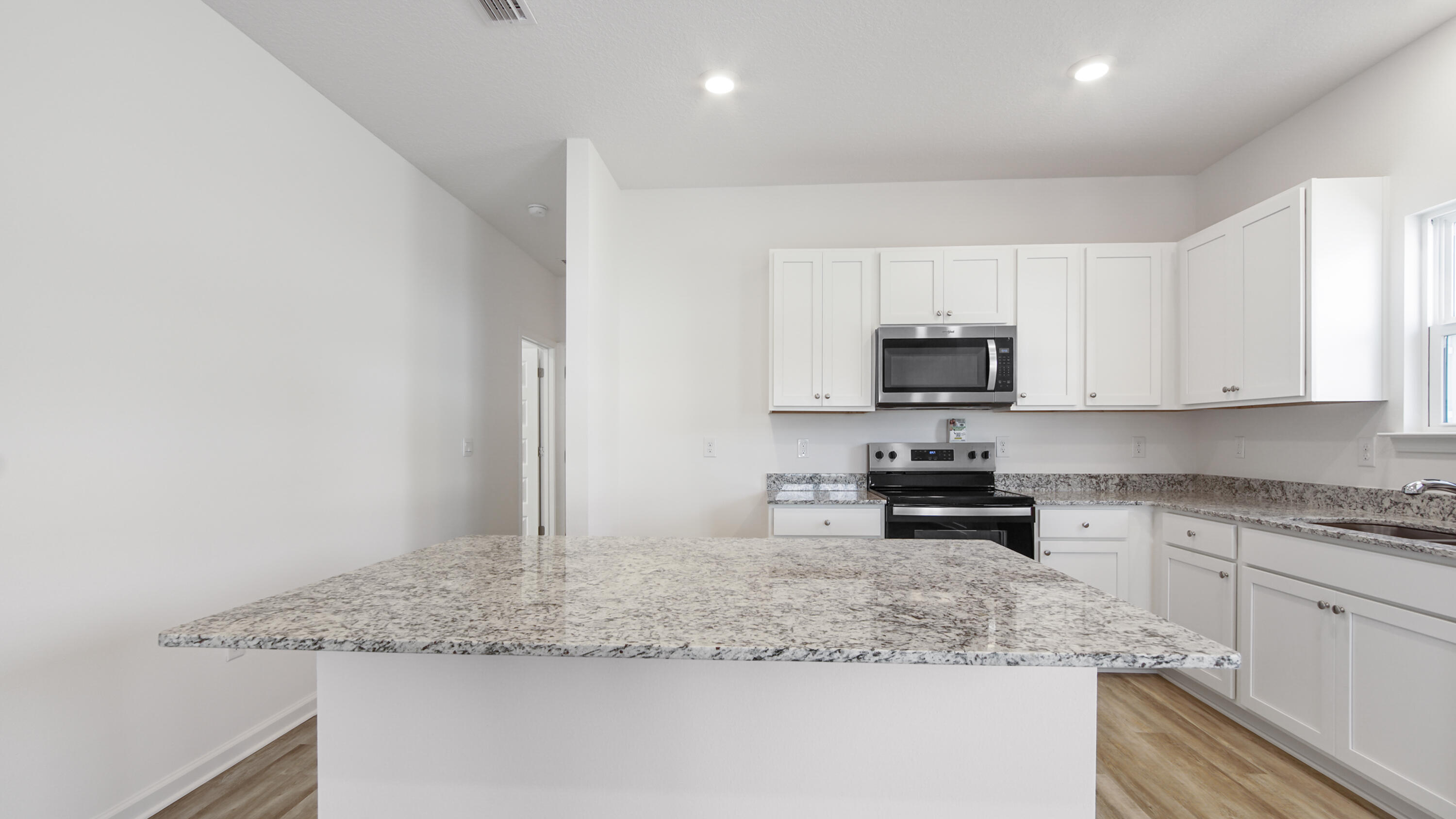 180 Huckleberry Street Freeport, FL 32439 - Photo 10 of 33 a kitchen with granite countertop white cabinets and a sink