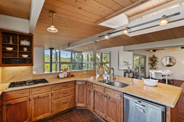 a kitchen with stainless steel appliances granite countertop a sink and a refrigerator