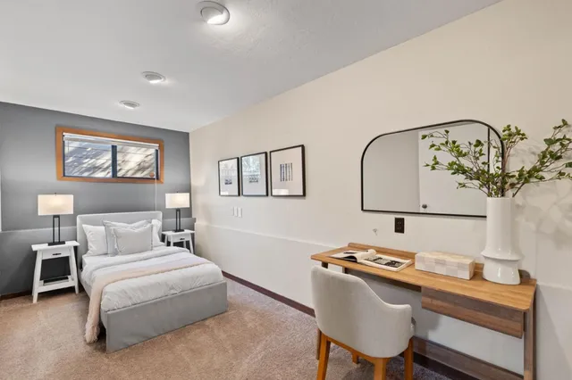 a bedroom with a bed and a lamp on dresser