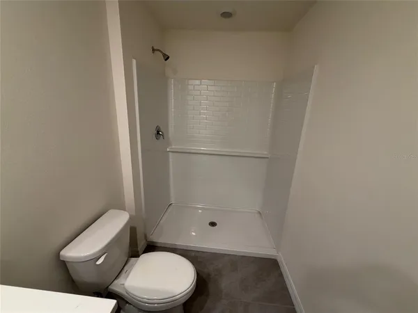a white toilet sitting next to a shower