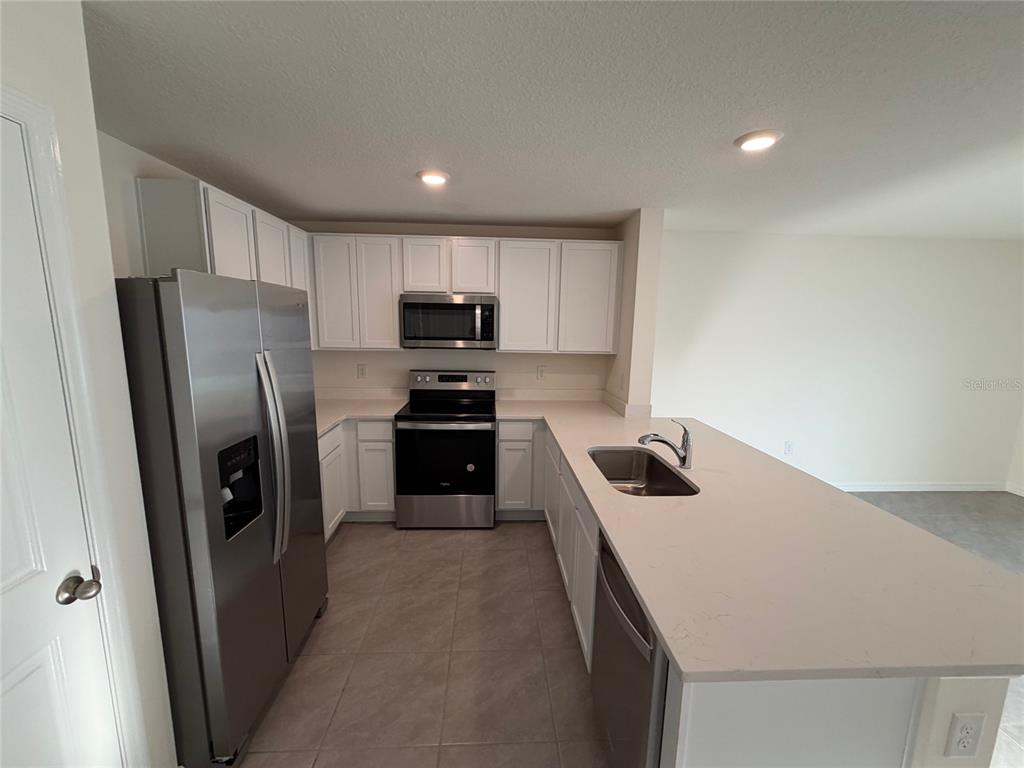 6685 South W 81st Loop Ocala, FL 34476 - Photo 4 of 31 a kitchen with a refrigerator a sink and a stove