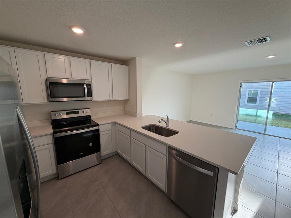 6685 South W 81st Loop Ocala, FL 34476 - Photo 6 of 31 a kitchen with a stove and a microwave