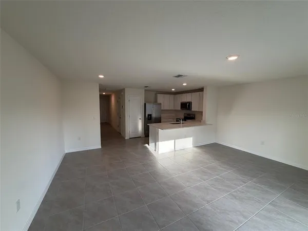a view of kitchen with refrigerator and window