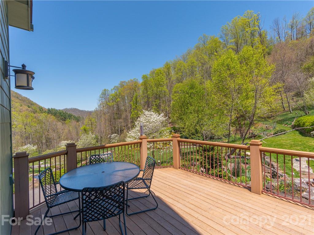122 Jump Cove Road Weaverville, NC 28787 - Photo 13 of 48 a view of a balcony with table and chairs and wooden floor