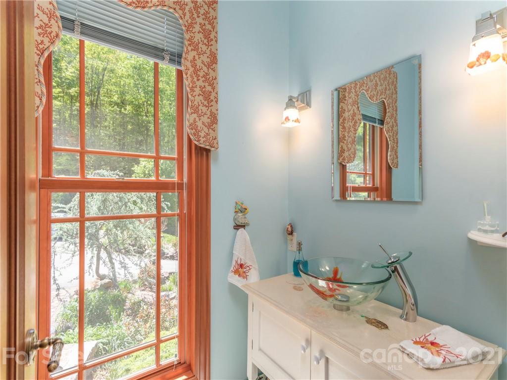 122 Jump Cove Road Weaverville, NC 28787 - Photo 17 of 48 a bathroom with a sink mirror and a window