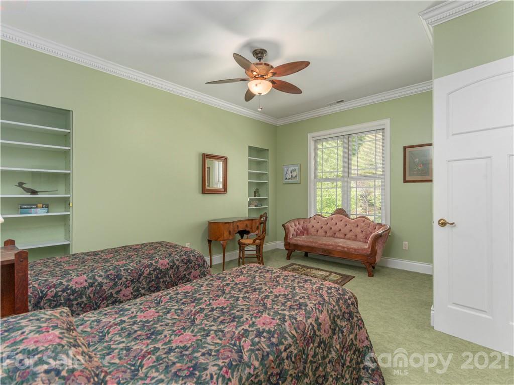 122 Jump Cove Road Weaverville, NC 28787 - Photo 23 of 48 a bedroom with a bed and a chandelier