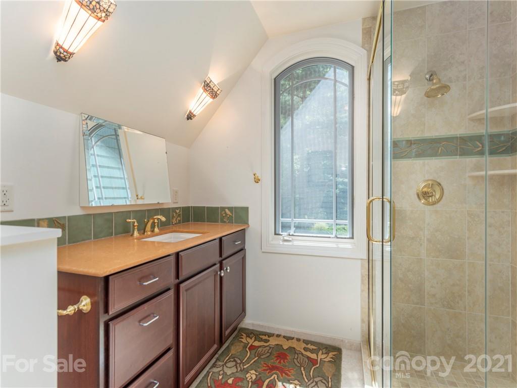 122 Jump Cove Road Weaverville, NC 28787 - Photo 27 of 48 a bathroom with a sink a mirror and a shower