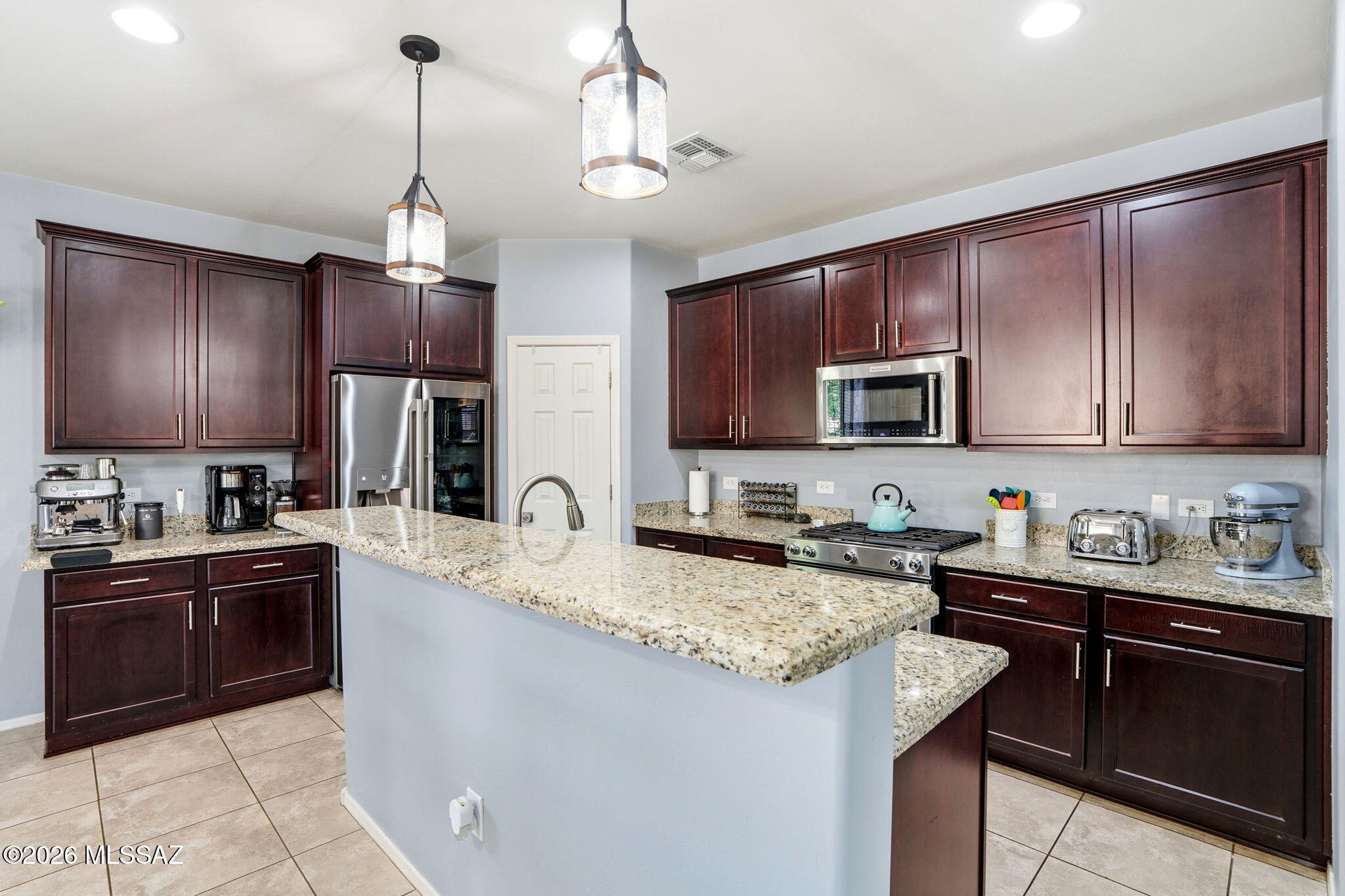 211 East Refuge Loop Vail, AZ 85641 - Photo 10 of 48 a kitchen with granite countertop stainless steel appliances a sink stove and microwave