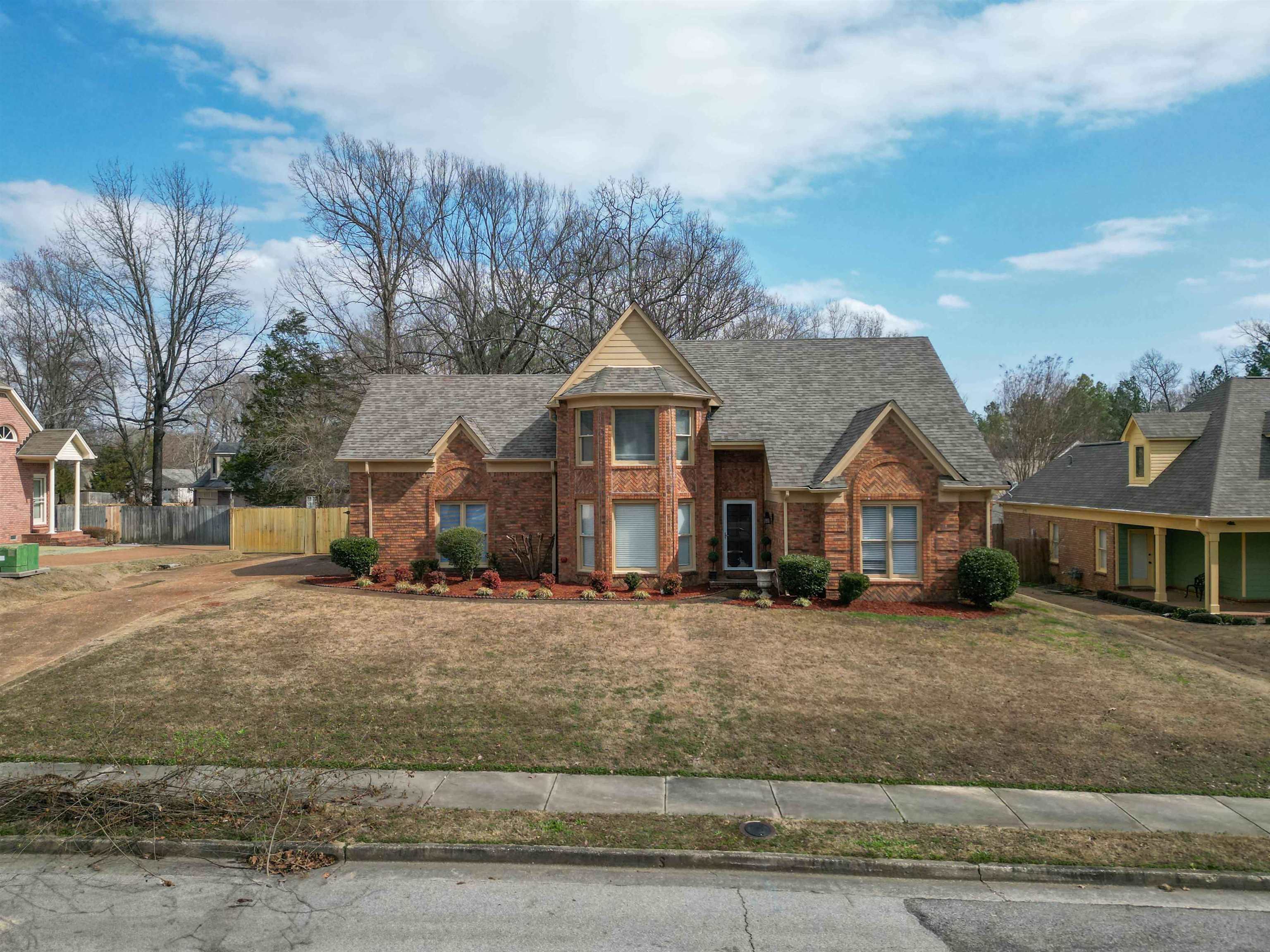 View of front of house with brick siding and roof with shingles