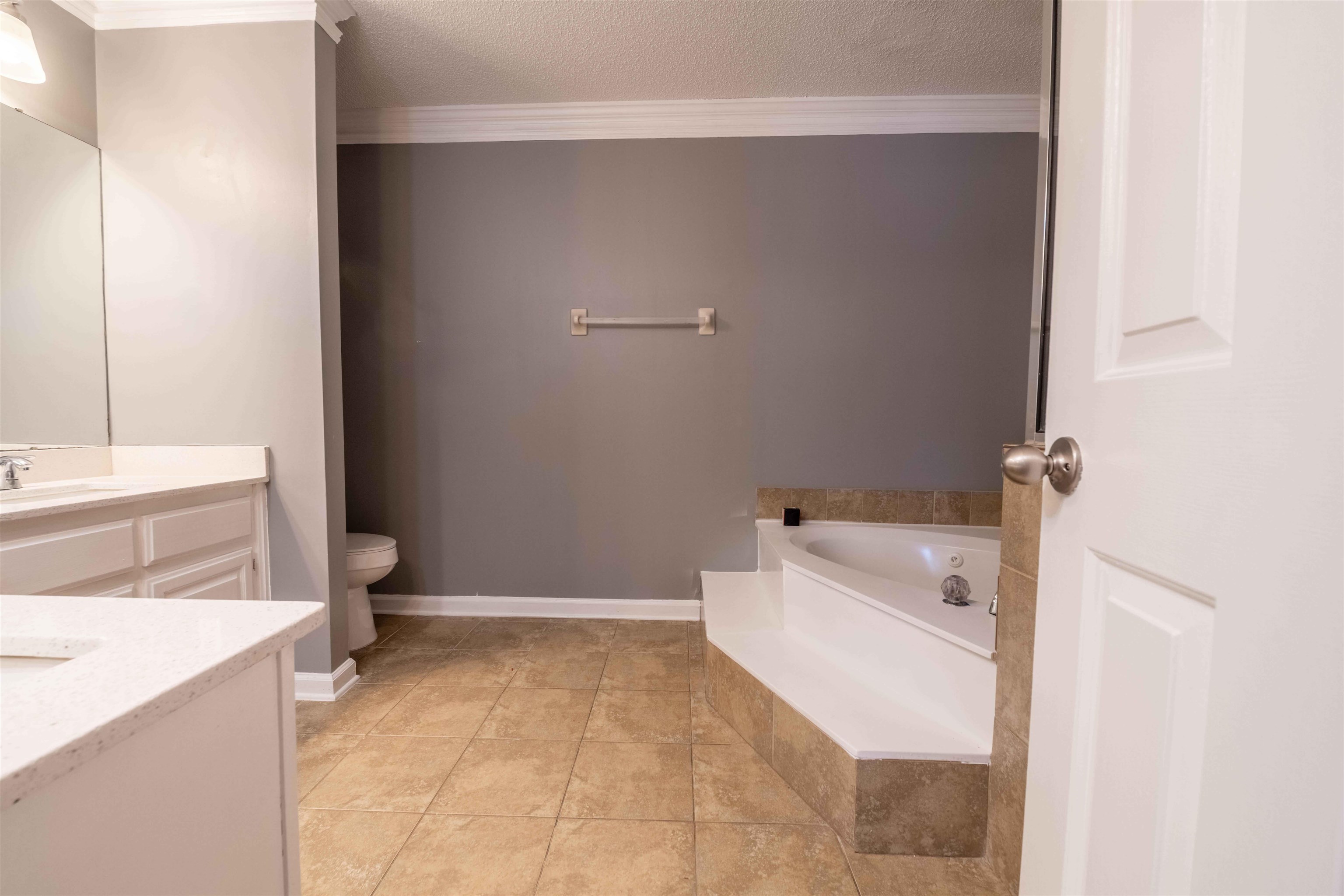 2630 Davies Plantation Road Memphis, TN 38016 - Photo 13 of 37 Full bathroom with vanity, a textured ceiling, a bath, crown molding, and light tile patterned floors