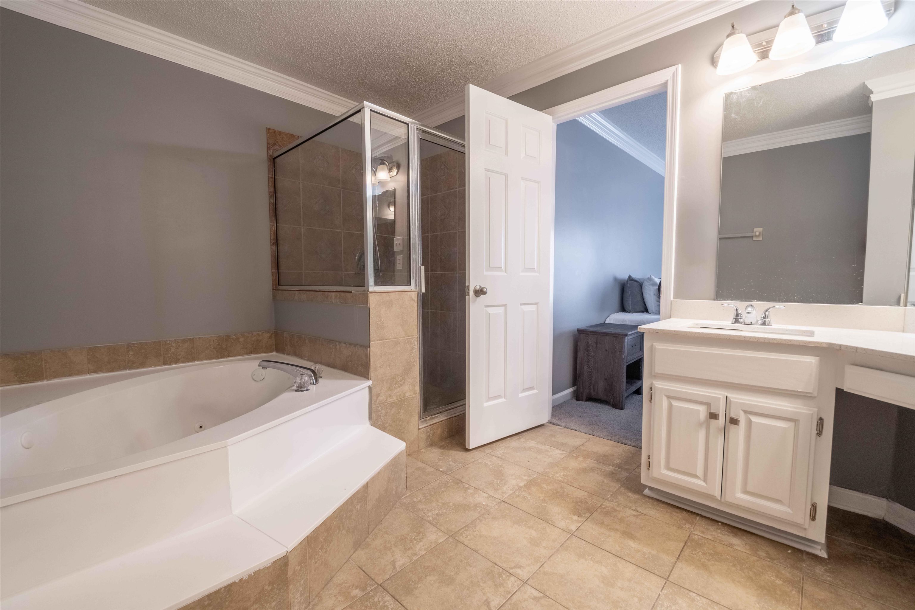 2630 Davies Plantation Road Memphis, TN 38016 - Photo 14 of 37 Bathroom with vanity, a stall shower, crown molding, a garden tub, and a textured ceiling