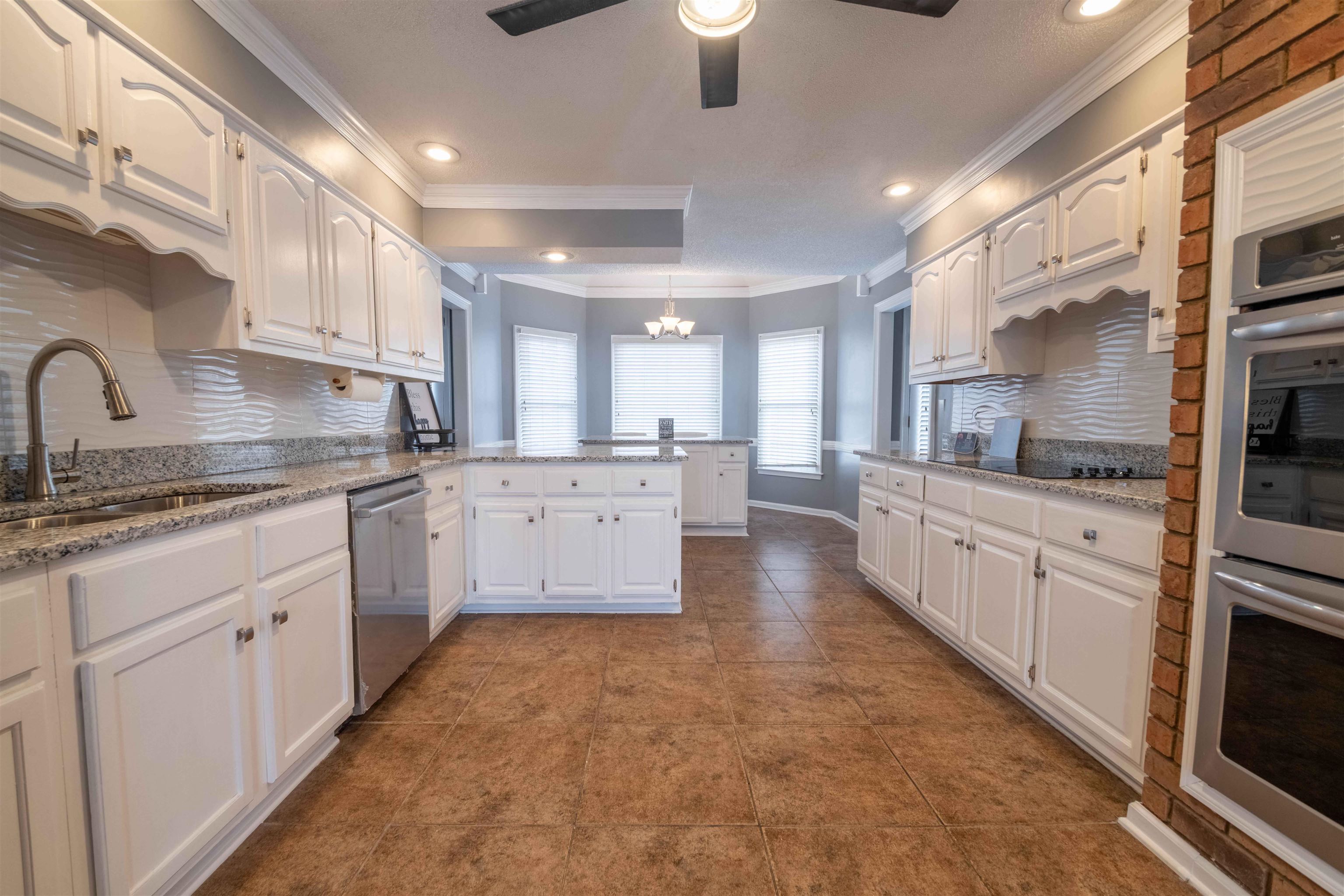 2630 Davies Plantation Road Memphis, TN 38016 - Photo 16 of 37 Kitchen with a peninsula, tasteful backsplash, stainless steel appliances, light stone counters, and ornamental molding
