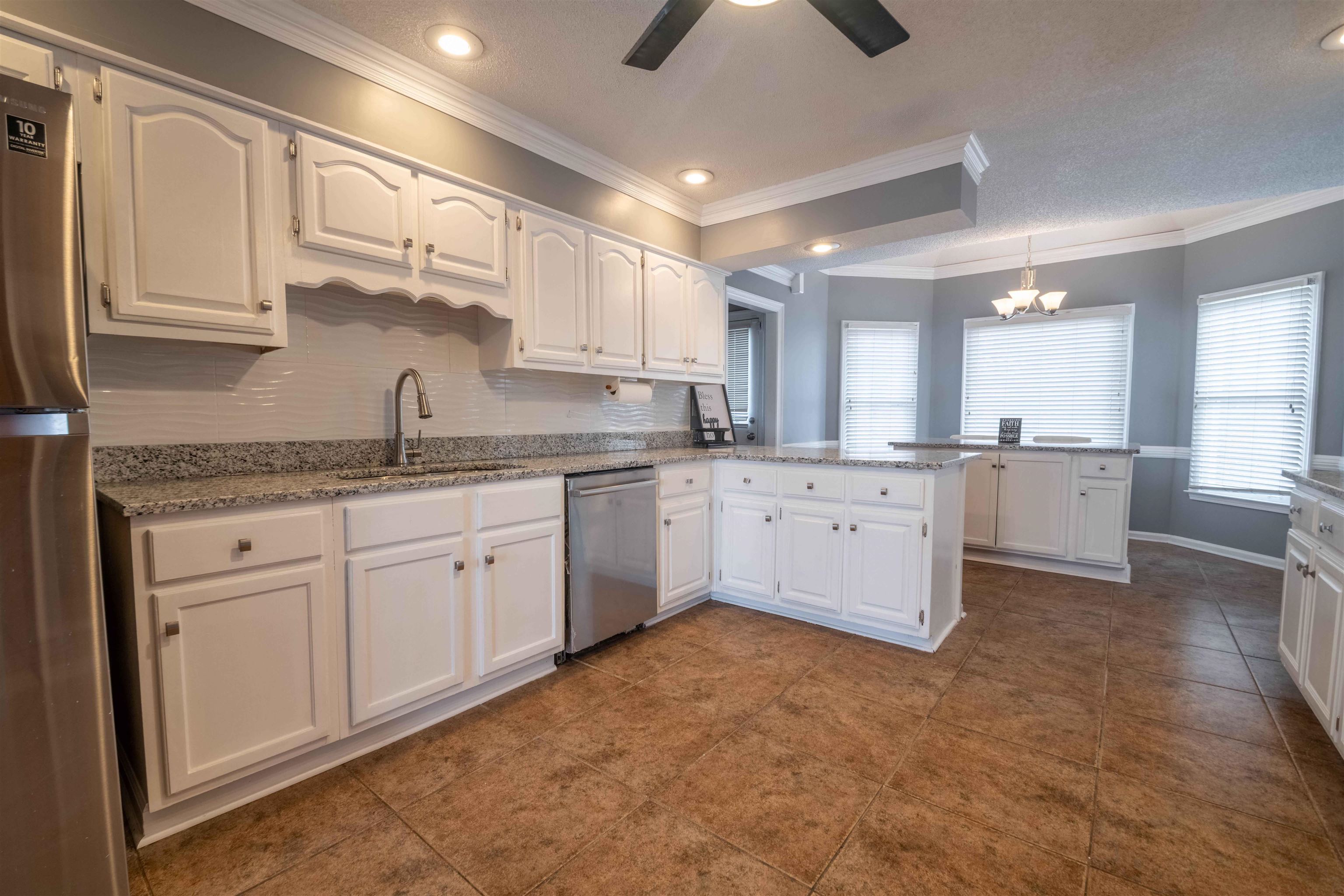 2630 Davies Plantation Road Memphis, TN 38016 - Photo 17 of 37 Kitchen featuring white cabinets, ceiling fan, stainless steel appliances, a peninsula, and backsplash