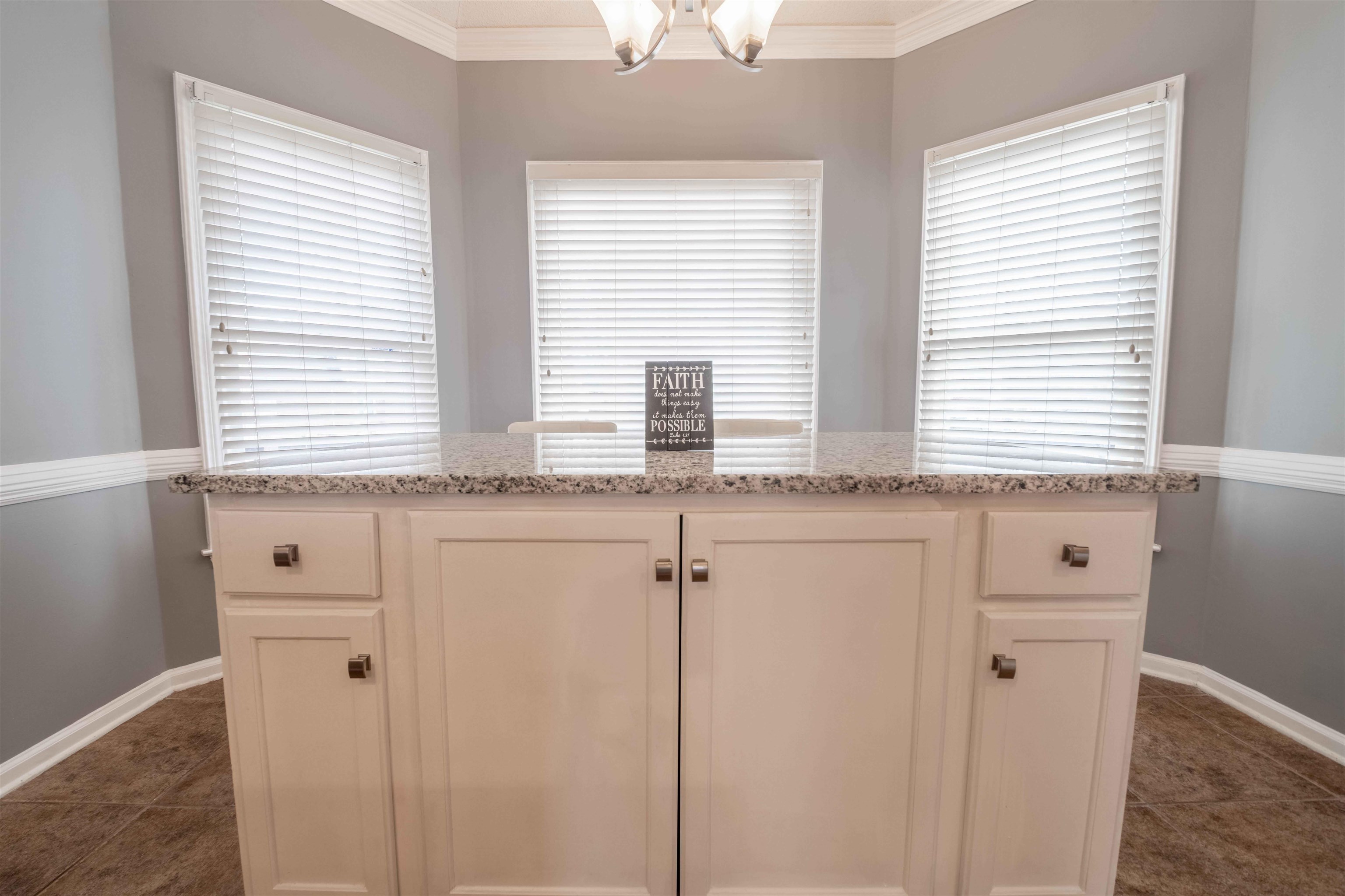2630 Davies Plantation Road Memphis, TN 38016 - Photo 24 of 37 Kitchen with ornamental molding, light stone countertops, white cabinetry, a chandelier, and a kitchen island