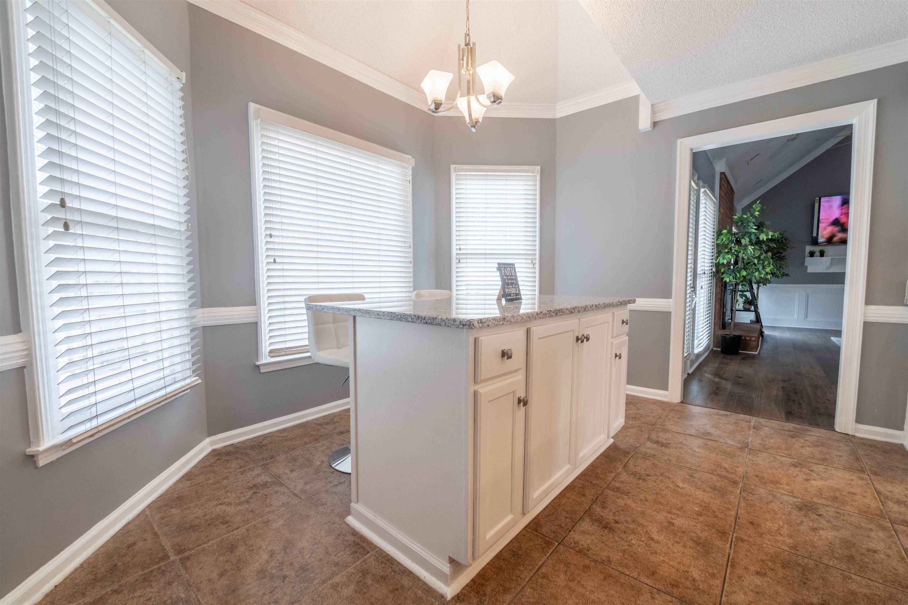 2630 Davies Plantation Road Memphis, TN 38016 - Photo 25 of 37 Kitchen with vaulted ceiling, white cabinetry, a center island, light stone countertops, and a chandelier