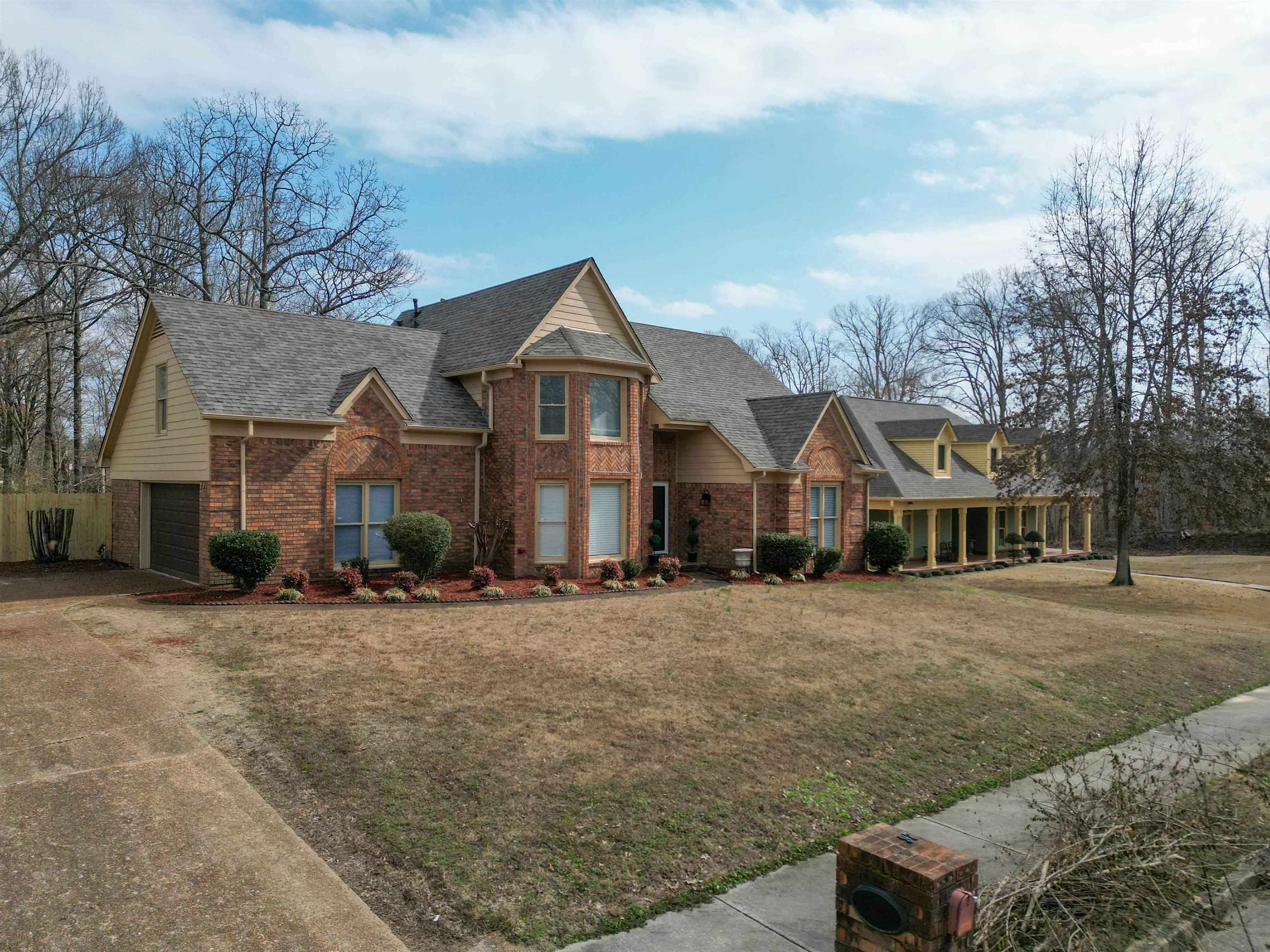 2630 Davies Plantation Road Memphis, TN 38016 - Photo 3 of 37 View of front of home with covered porch, a front yard, brick siding, a shingled roof, and concrete driveway