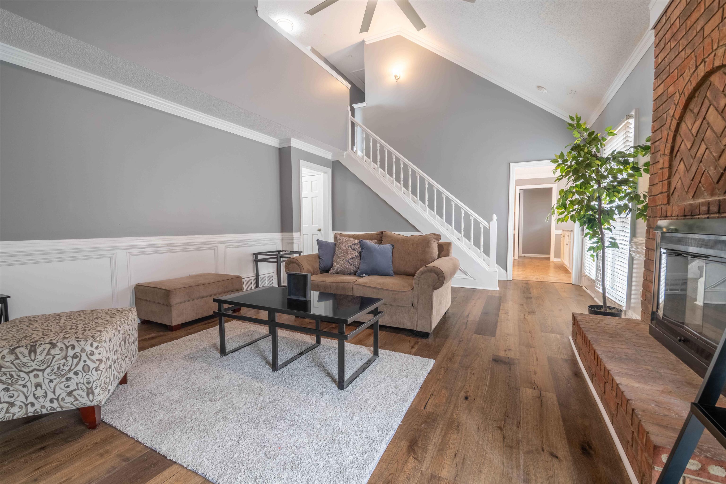 2630 Davies Plantation Road Memphis, TN 38016 - Photo 29 of 37 Living area with crown molding, lofted ceiling, wood finished floors, a brick fireplace, and a ceiling fan