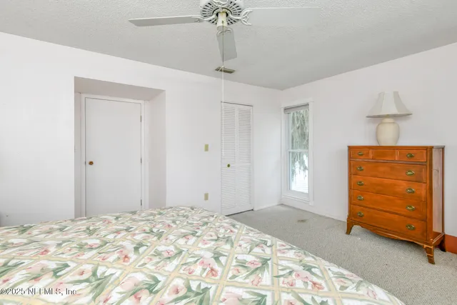 a bedroom with a dresser and a chandelier