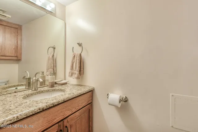 a bathroom with a granite countertop sink and a mirror