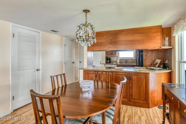 a dining room with furniture a chandelier and wooden floor