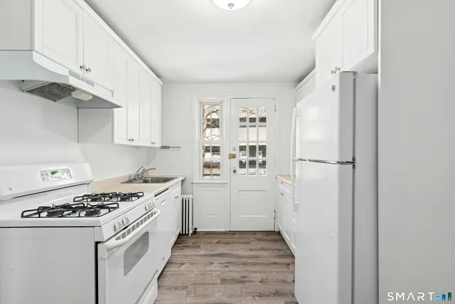 a kitchen with white cabinets and white appliances