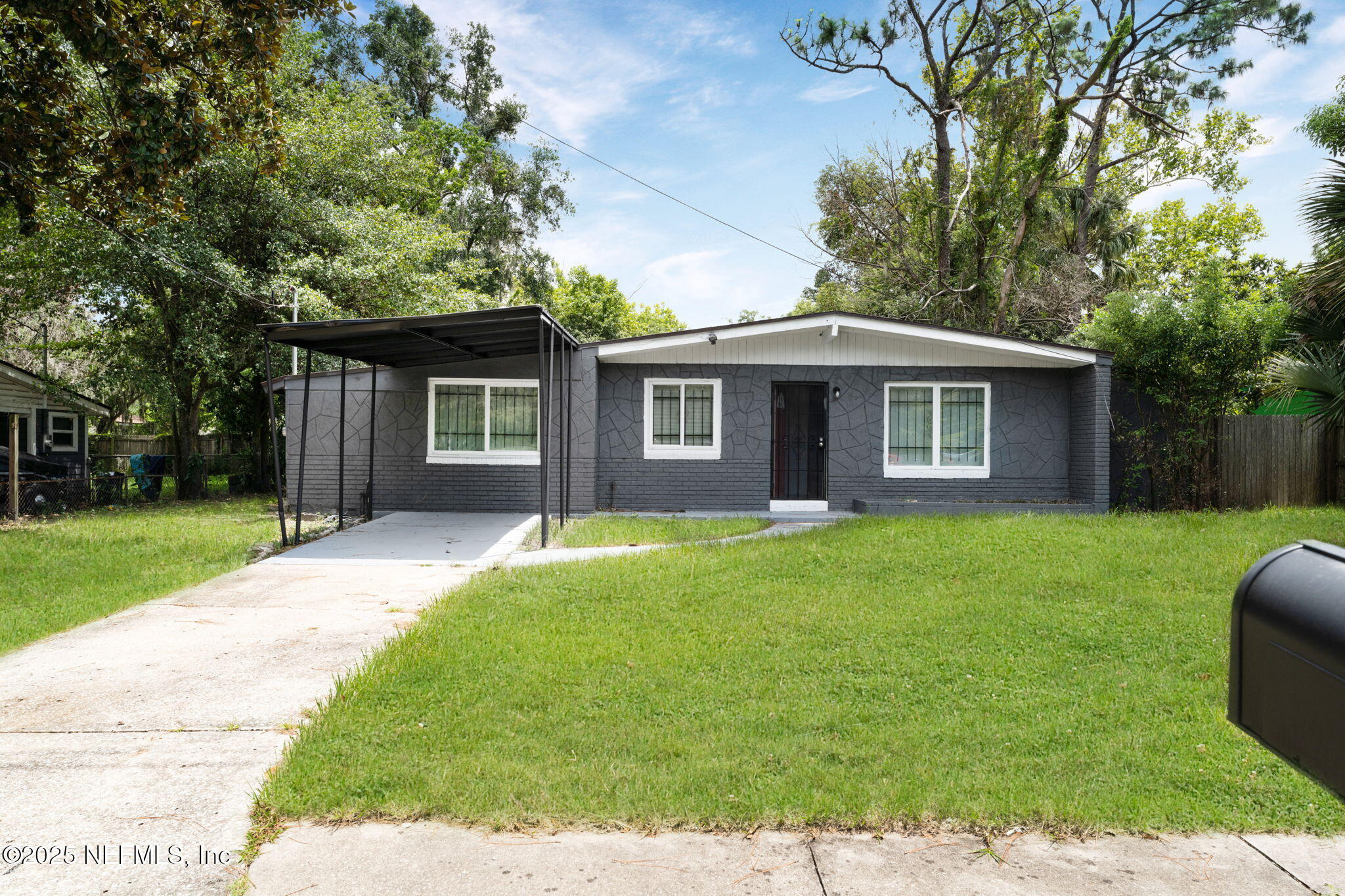a view of a yard in front of a house with large trees