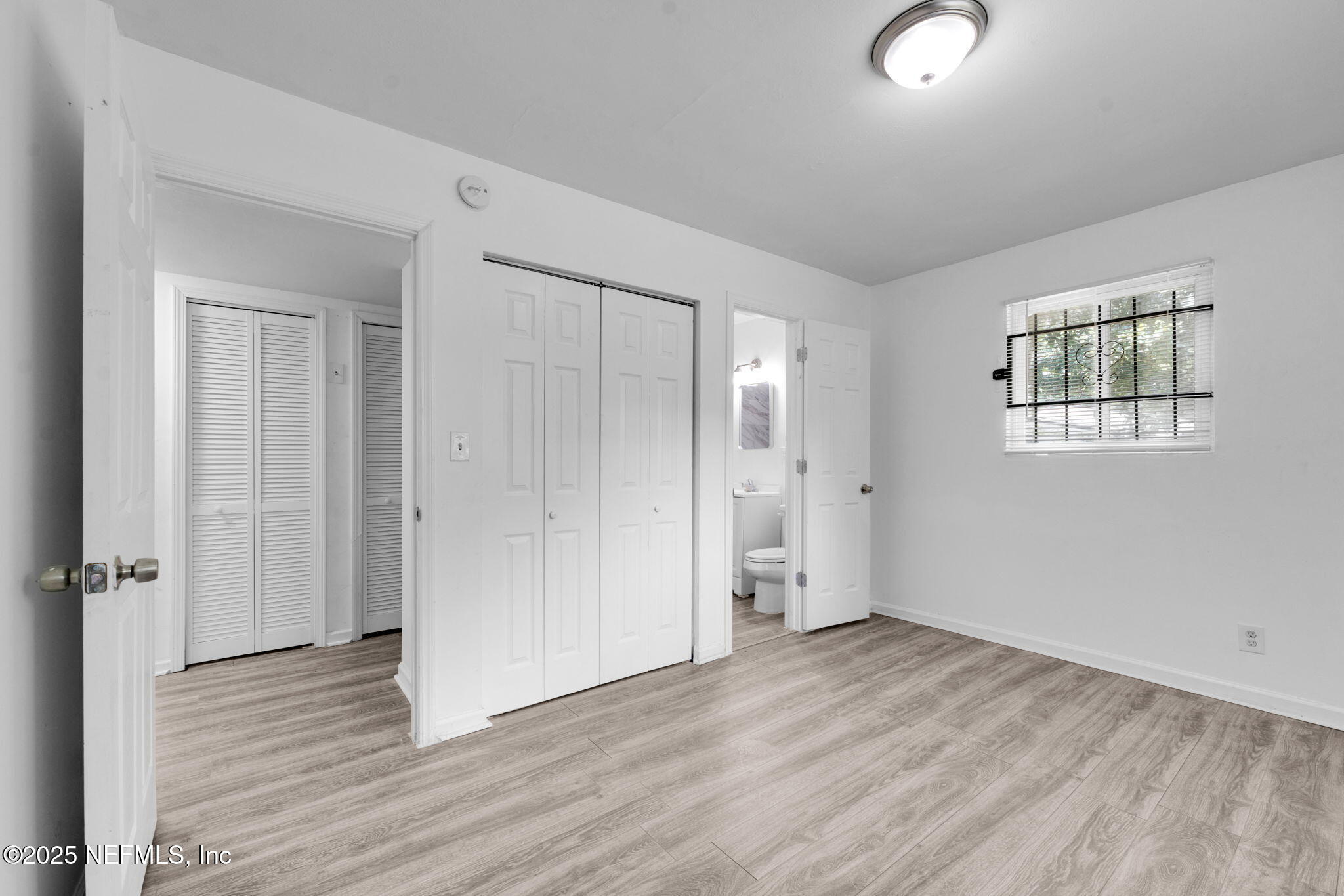 9155 Sibbald Road Jacksonville, FL 32208 - Photo 16 of 22 an empty room with wooden floor and windows
