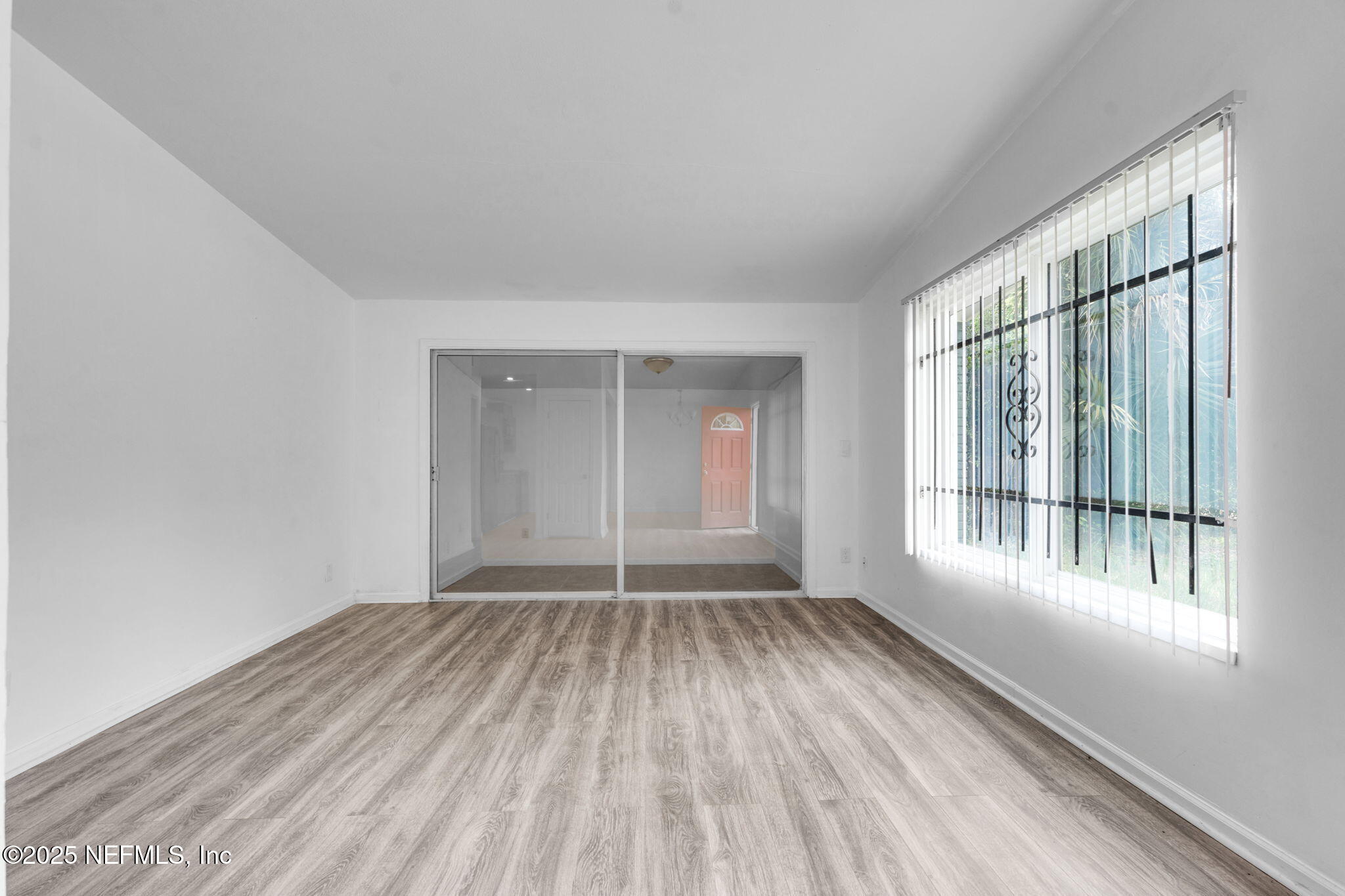 9155 Sibbald Road Jacksonville, FL 32208 - Photo 7 of 22 a view of an empty room with wooden floor and a window