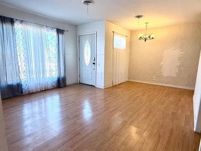 a view of a room with wooden floor and a flat screen tv