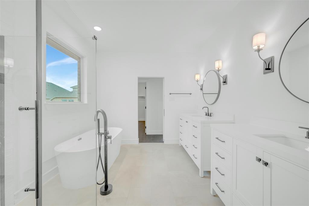 1002 Ashcroft Lane Justin, TX 76247 - Photo 14 of 29 a bathroom with a double vanity sink a toilet and a mirror