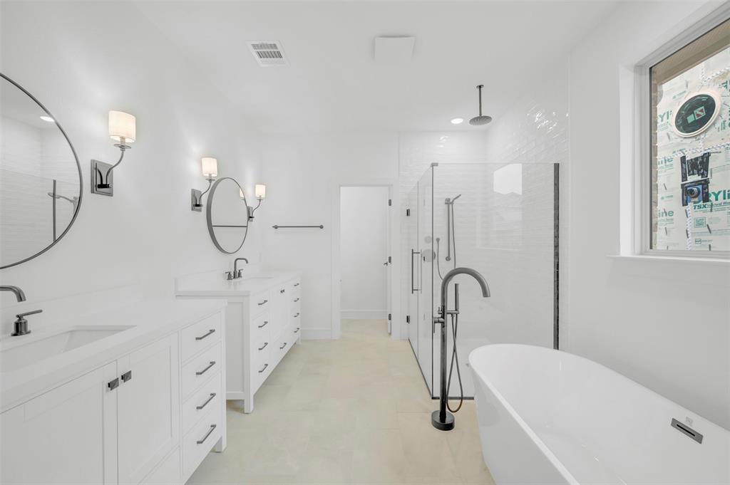 1002 Ashcroft Lane Justin, TX 76247 - Photo 17 of 29 a bathroom with a tub sink double vanity and mirrors