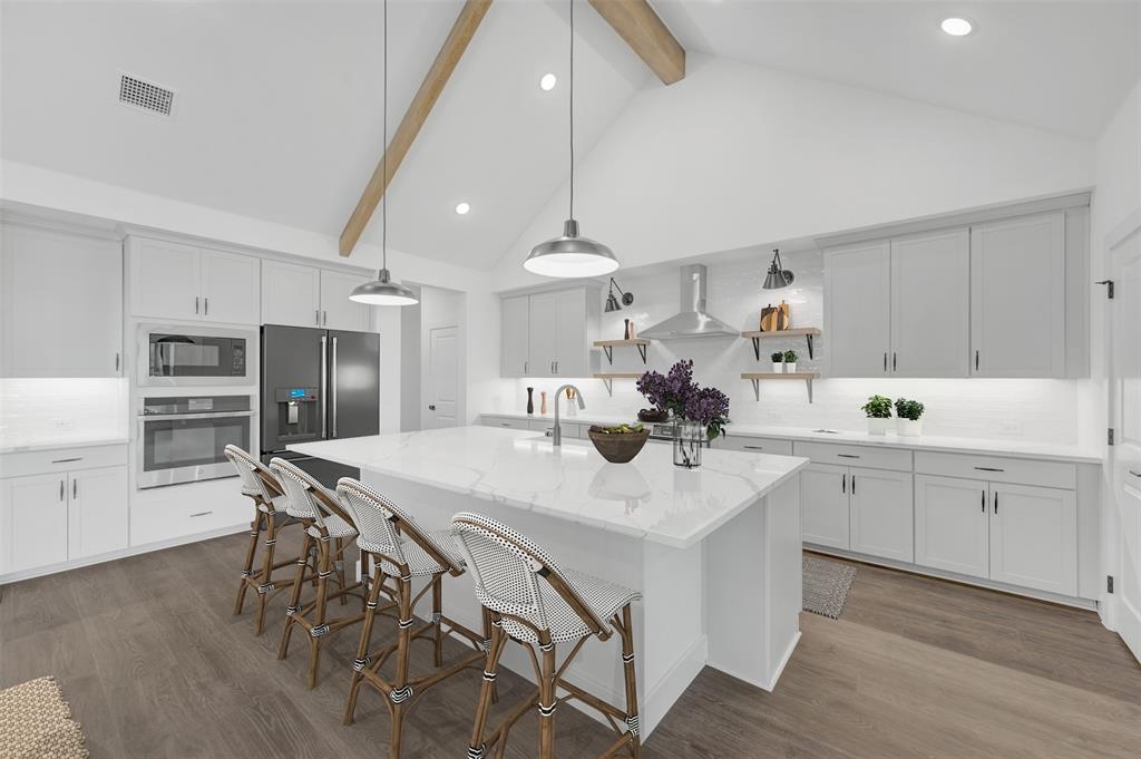 1002 Ashcroft Lane Justin, TX 76247 - Photo 8 of 29 a kitchen with a dining table chairs sink and cabinets