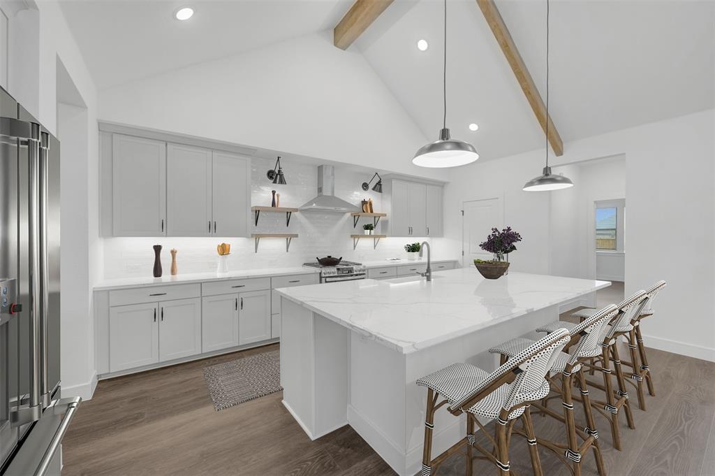 1002 Ashcroft Lane Justin, TX 76247 - Photo 10 of 29 a kitchen with a sink a stove a refrigerator and white cabinets