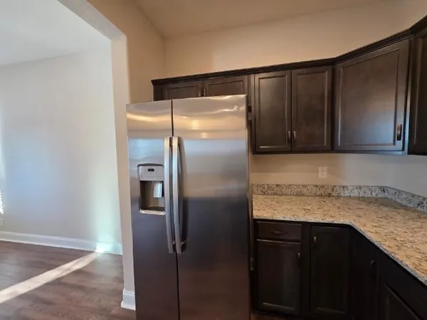 a kitchen with granite countertop stainless steel appliances a refrigerator and cabinets